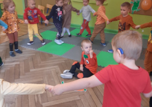 Dzieci tańczą dookoła chłopca przebranego za marchewkę